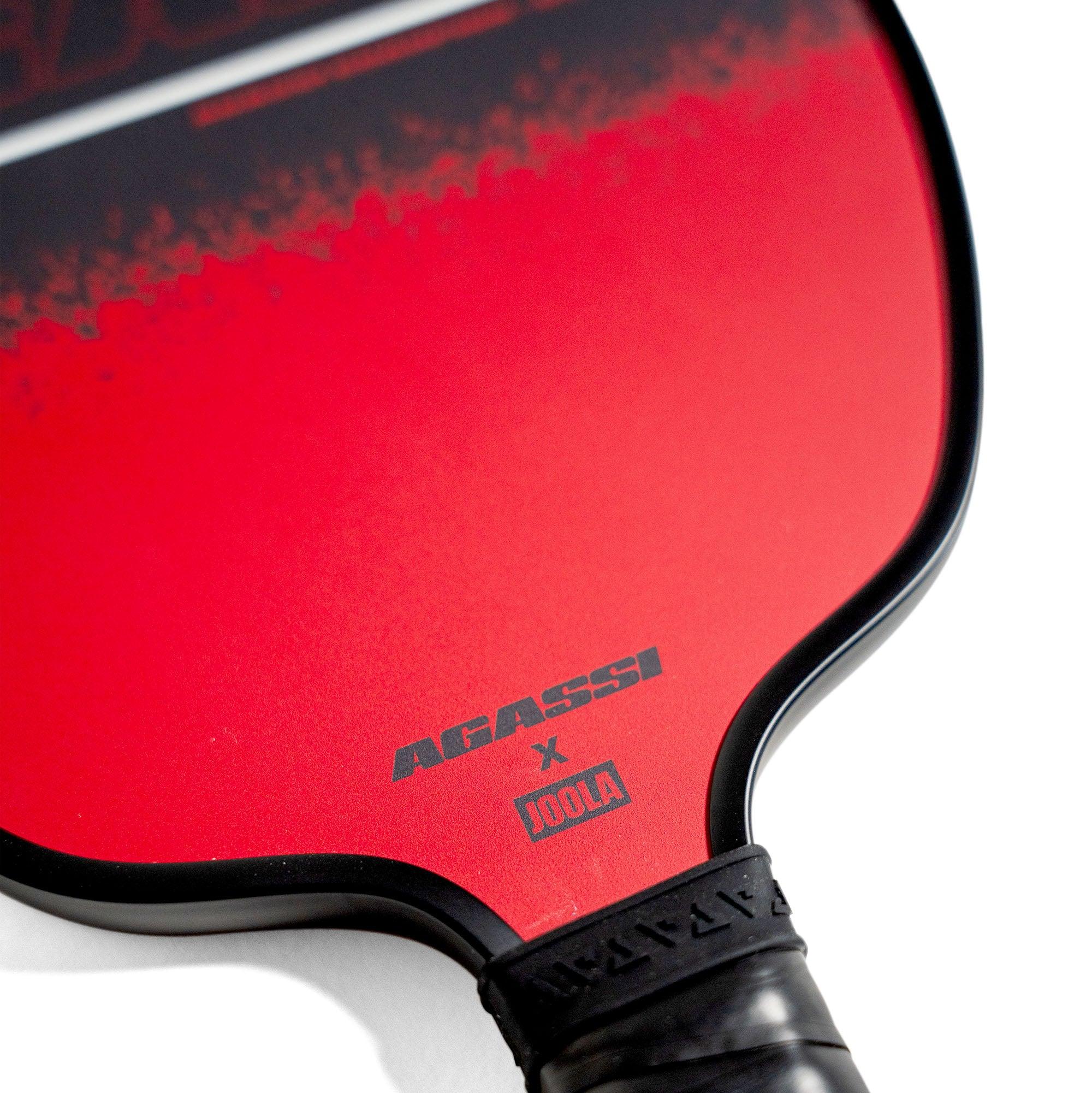Close-up of a red table tennis bat with the inscription "AGASSI x JOOLA".