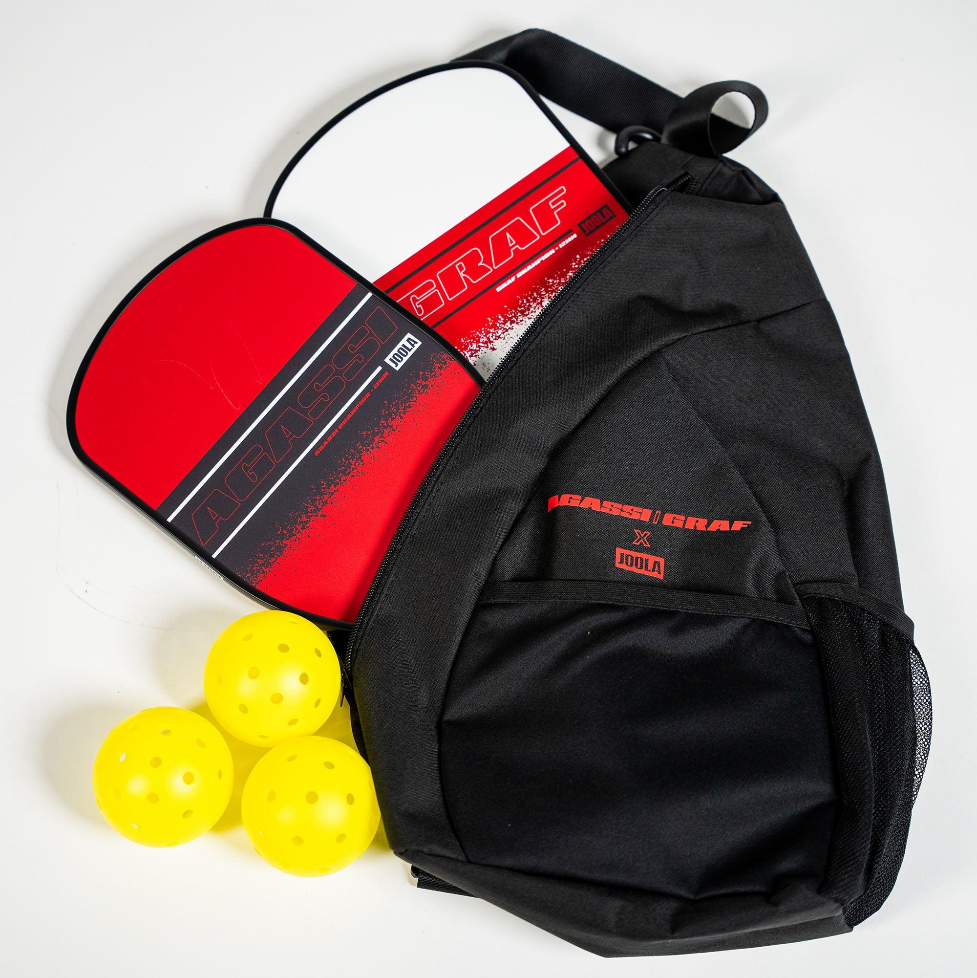 Black Pickleball bag with two red bats and three yellow Pickleball balls.